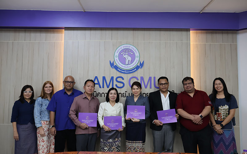 Participants in the closing ceremony gathered in a University classroom, posing in front of the University logo. Trainees hold their diplomas in their hands