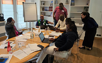 Dans une salle de réunion, six participants travaillent autour d'une salle ovale