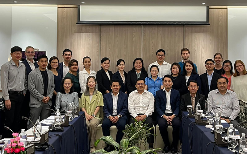 the 26 participants pose together in a meeting room