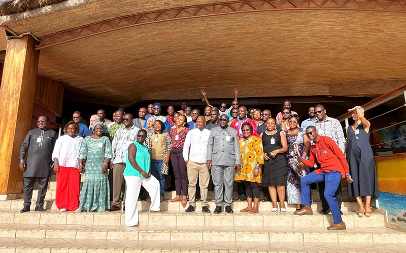 Un groupe de participants d'Afro-ACDx se tiennent debout sur des marches, à l'entrée d'un bâtimente